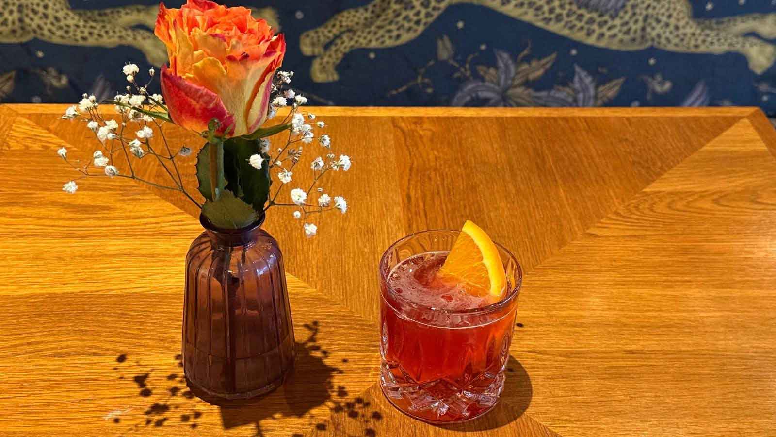 Blume und roter Drink auf einem Holztisch im VietRoyal Baldham